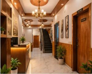 a lobby with a staircase and a hallway with potted plants at Hotel The Girnaar Near Valley View Dharampur Kasauli Road in Dharampur