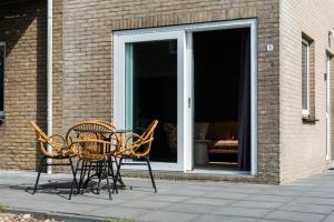 two chairs and a table in front of a window at De Viool Appartementen in Buren