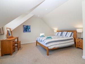 a bedroom with a bed and a desk in a attic at Meadowgreen Farmhouse in Forfar