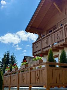 a house with a wooden fence with potted plants at Villa Bergbliss in Bukovel