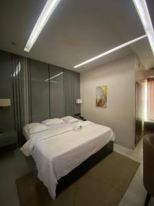 a bedroom with a large bed with white sheets and pillows at Wesley Hotels in Benin City +6 photos