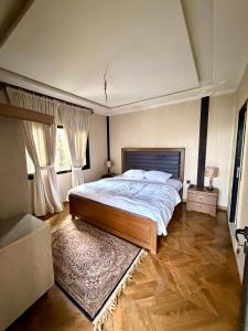 a bedroom with a large bed and two windows at The Pinecrest in Nathia Gali