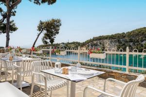 a restaurant with tables and chairs next to a pool at Casa Nina in Patitiri