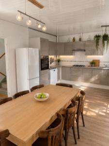 a kitchen with a wooden table with a bowl of fruit on it at Gîte Le Riviéra in Almenêches