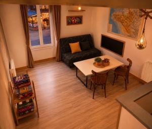 a living room with a table and a couch at Gîte Le Riviéra in Almenêches