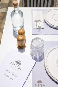 a table with white plates and a bottle of water at Casa Nina in Patitiri