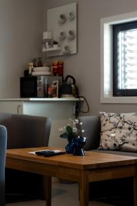 a wooden table with a vase of flowers on it at Stor-Elvdal Hotell in Koppang +32 photos