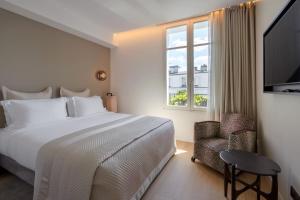 a bedroom with a bed and a window and a chair at Montmartre Residence in Paris +103 photos
