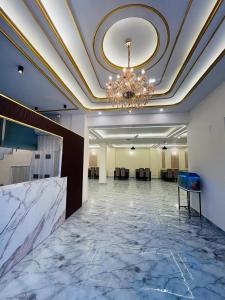 a large room with a chandelier and a large room with tables at Mount Green Hotel Bharatgarh in Bharatgarh