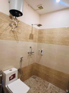 a bathroom with a toilet and a shower at Mount Green Hotel Bharatgarh in Bharatgarh +12 photos