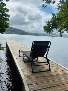 a chair sitting on a dock next to the water at Villa Libel'ulle in Le Robert