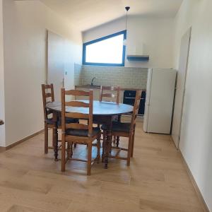 a dining room with a table and chairs and a refrigerator at Gite Aubanel' Drôme Provencale in Saint-Auban-sur-Ouvèze