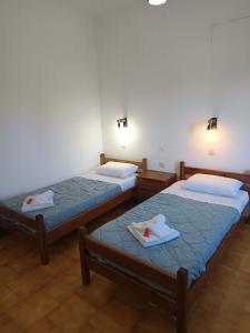 two beds in a room with towels on them at Dimosthenis Apartments in Agios Georgios