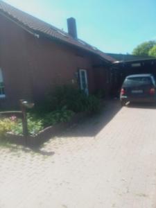 a car parked in front of a house at Heikeland in Südbrookmerland