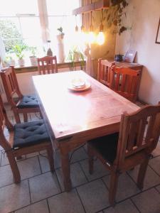 a dining room table with chairs and a wooden table at Heikeland in Südbrookmerland