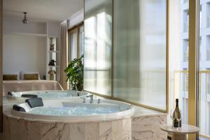 a large bathroom with a tub with a window at Boulevard Drobnera SPA&Wellness - Restaurant PONTI - Widok na Odre in Wrocław