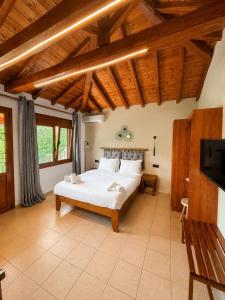a bedroom with a white bed and wooden ceilings at Sergios in Koukounaries +52 photos