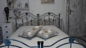una camera con un letto con due cuscini di L'Isola Felice e Trulli Sotto Le Stelle a Castellana Grotte