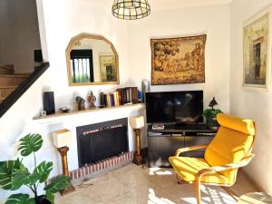 a living room with a yellow chair and a television at Casa Tranquila La Duquesa in Manilva