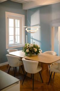 a dining room table with a vase of flowers on it at Anfiteatro - Spacious and elegant residence in Lucca