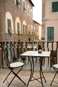 a bottle of wine sitting on a table with two chairs at Anfiteatro - Spacious and elegant residence in Lucca
