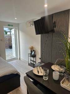 a living room with a table with a tv on the wall at Brigstock 9 in Thornton Heath