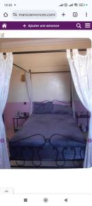 a page of a bedroom with a bed with curtains at Dar ojkak in Essaouira