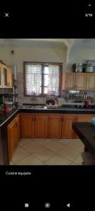 a kitchen with wooden cabinets and a sink and a window at Dar ojkak in Essaouira