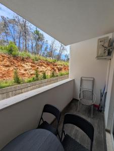 a balcony with two chairs and a window with a view at Studio apartment LISI 2 in Lezhë +5 photos