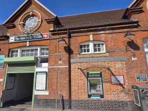 an old brick building with a pay meter in front at Brigstock 9 in Thornton Heath