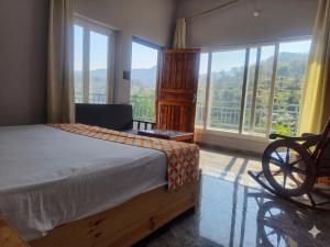 a bedroom with a bed and a large window at Ganga Nature Nest in Hawālbāgh