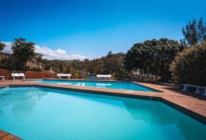 a large swimming pool with blue water at Umdloti Holiday Resort 208 in Umdloti +9 photos