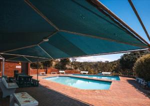 a large green umbrella over a swimming pool at Umdloti Holiday Resort 208 in Umdloti