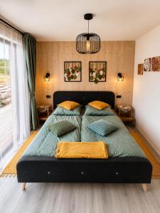 a bedroom with a large green bed with two pillows at Modern House with Private Pool & Terrace in Červená Třemešná +10 photos