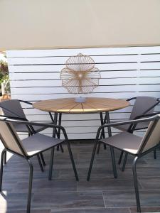 a wooden table with two chairs and an umbrella at Valantas Garden Suite in Lartos