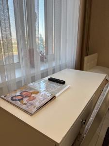 a magazine on a table with a remote control on it at Amari in Uralʼskiy Prigorodnyy