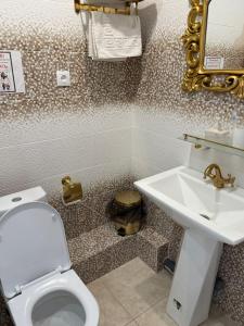 a bathroom with a toilet and a sink at Amari in Uralʼskiy Prigorodnyy