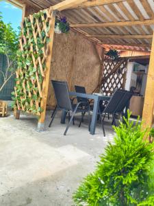 a patio with a table and chairs under a wooden pergola at Casa Tesmao in Constanţa