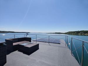 a bench sitting on a dock next to the water at Bateau Lac du Der - Nuisement - Navigation in Les Petites-Côtes