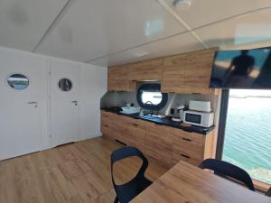 a kitchen with wooden cabinets and a table with chairs at Bateau Lac du Der - Nuisement - Navigation in Les Petites-Côtes