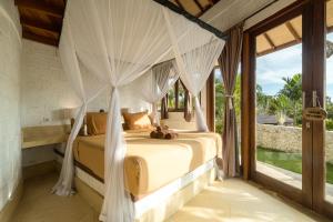 a bedroom with a bed with white drapes at Biu Biu Resort Bali in Jimbaran +155 photos