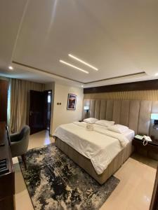 a large bedroom with a large bed and a desk at Wesley Hotels in Benin City