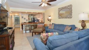 a living room with blue couches and a dining room at B105 Moon Bay in Key Largo