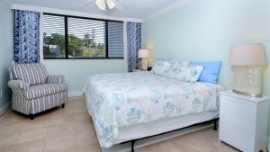 a bedroom with a bed and a chair and a window at B105 Moon Bay in Key Largo +36 photos