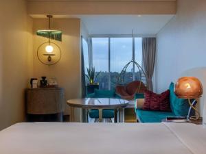 a hotel room with a bed and a table and chairs at Gem Forest Hotel Nairobi - MGallery Collection in Nairobi +163 photos