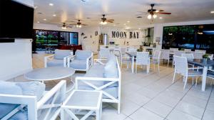 a restaurant with white chairs and tables and a room with windows at B405 Moon Bay in Key Largo