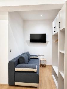 a living room with a blue couch and a tv at Nefonas Guest House in Skiathos