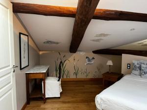 a bedroom with a bed and a wooden ceiling at L'Ecrin de Launac in Launac