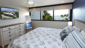 a bedroom with a bed and two large windows at A409 Moon Bay in Key Largo +36 photos