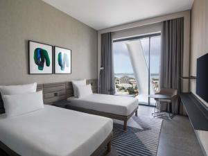 a hotel room with two beds and a window at Novotel Abidjan Marcory in Abidjan +150 photos